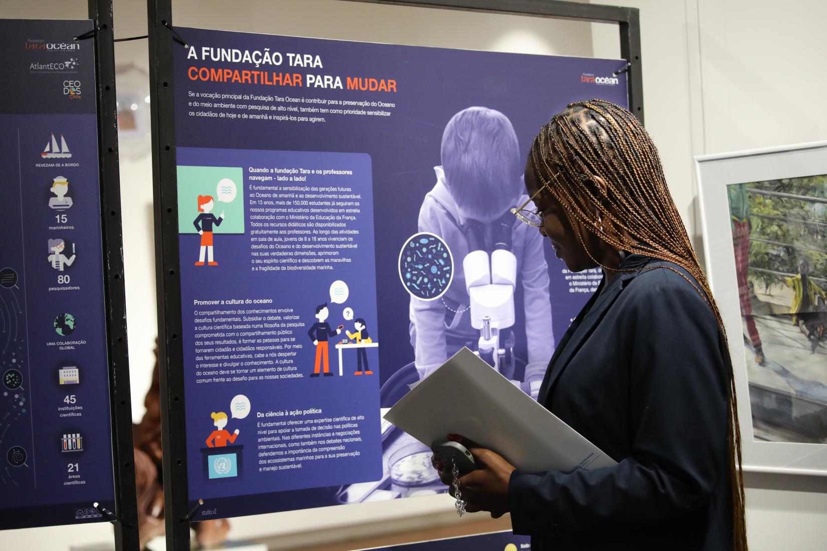 Participante a ver a exposição sobre os oceanos, patente durante a "Blue Talk" no Museu da Moeda.