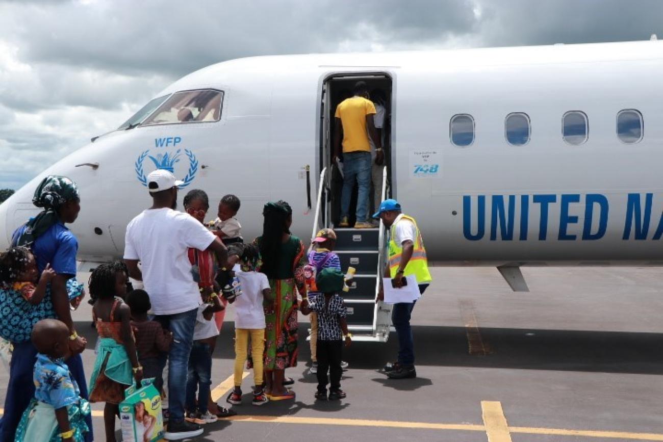 Refugiados que regressam a embarcar num avião com destino à RDC durante a repatriação voluntária