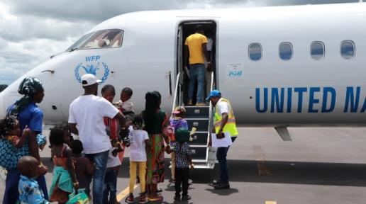 Refugiados que regressam a embarcar num avião com destino à RDC durante a repatriação voluntária